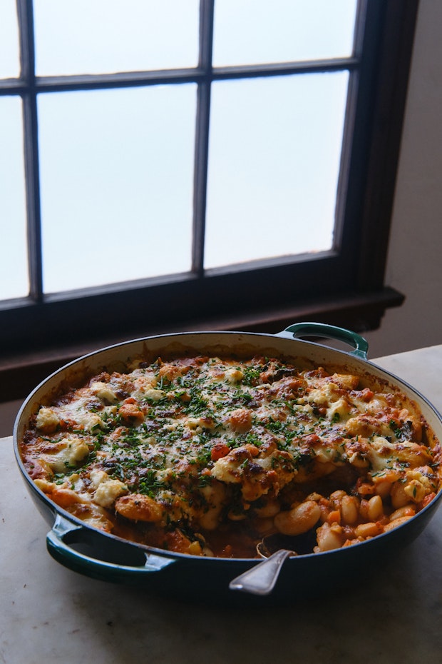 pizza beans in a large skillet topped with melted cheese served on a table