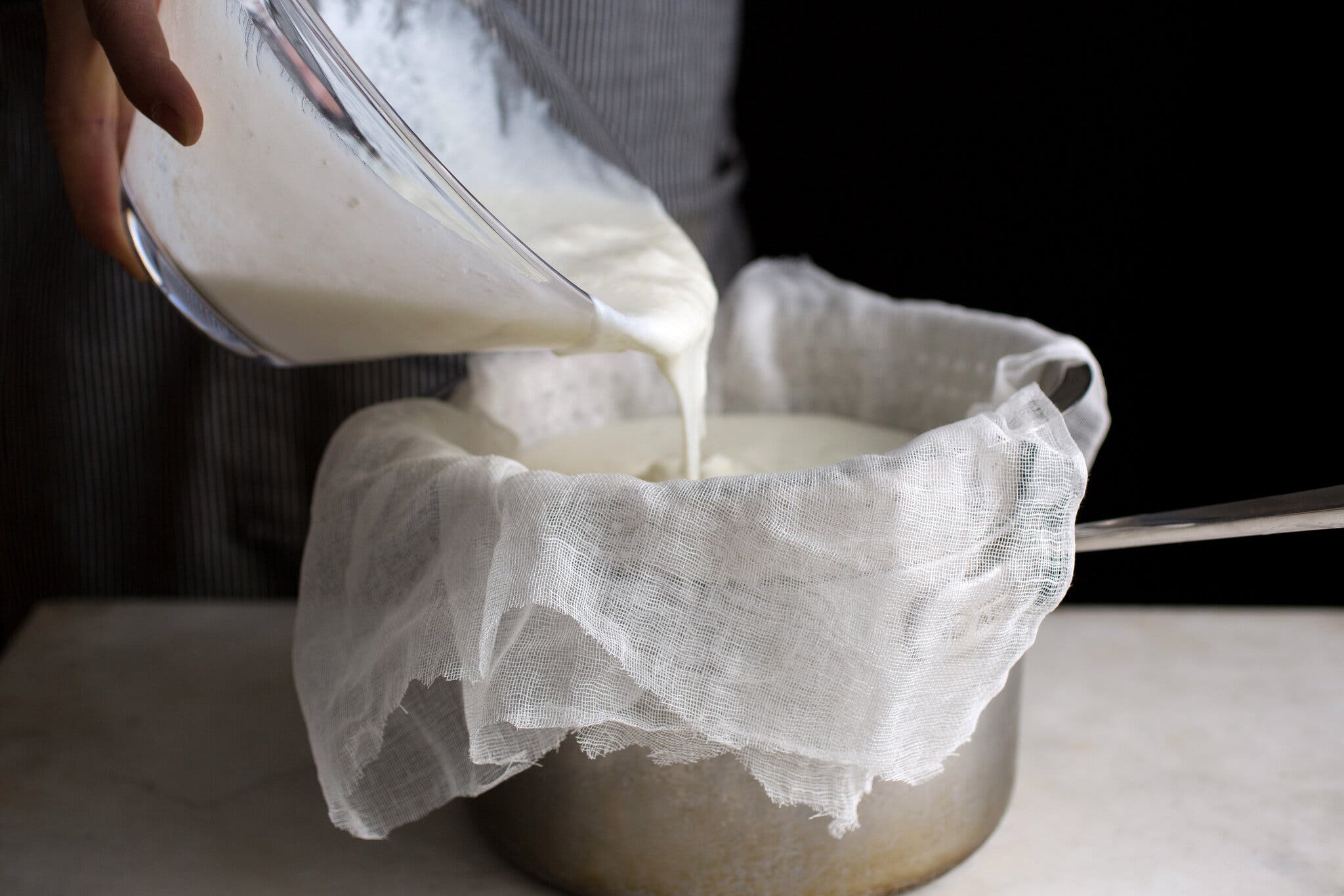 A side image of yogurt being strained through a cheesecloth.