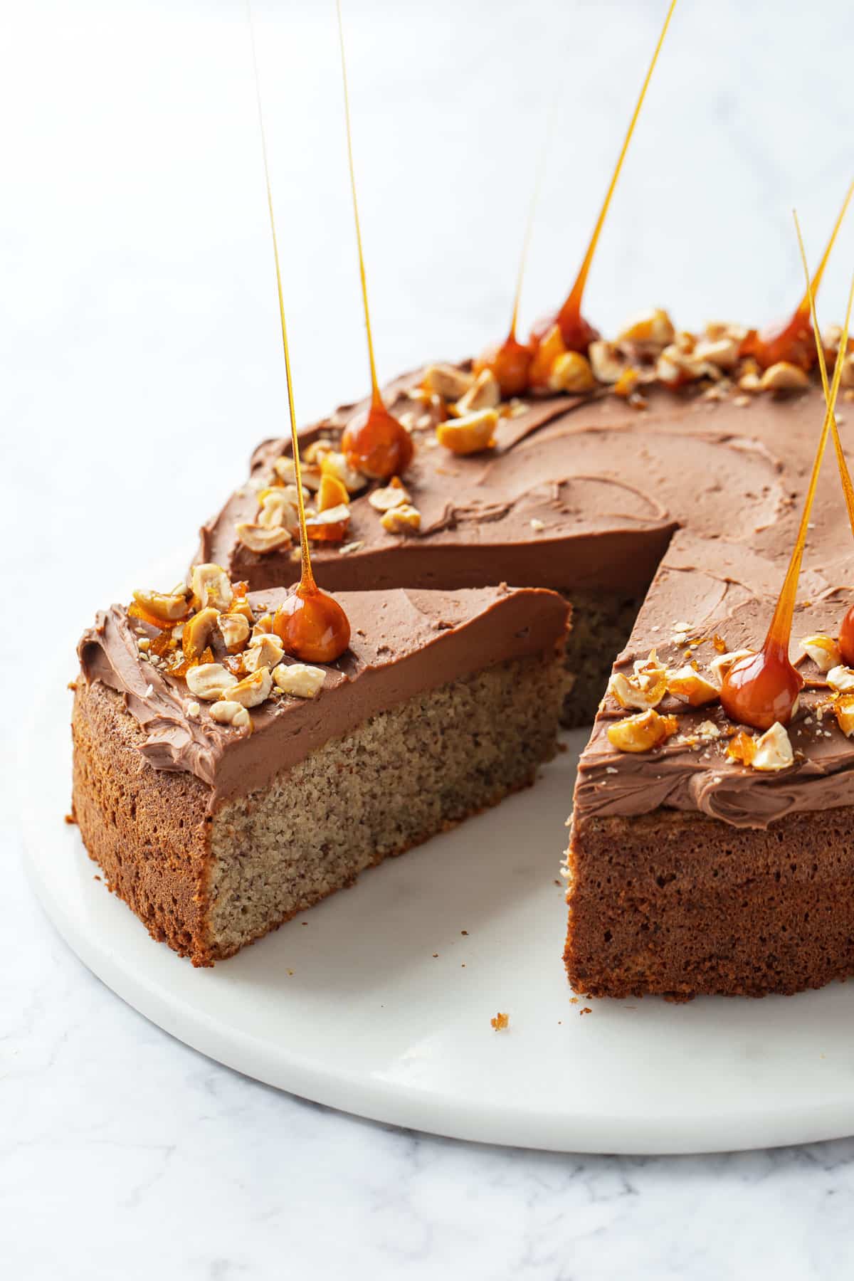 Flourless Hazelnut Cake with Nutella Whipped Ganache with one slice cut out to show the layers.