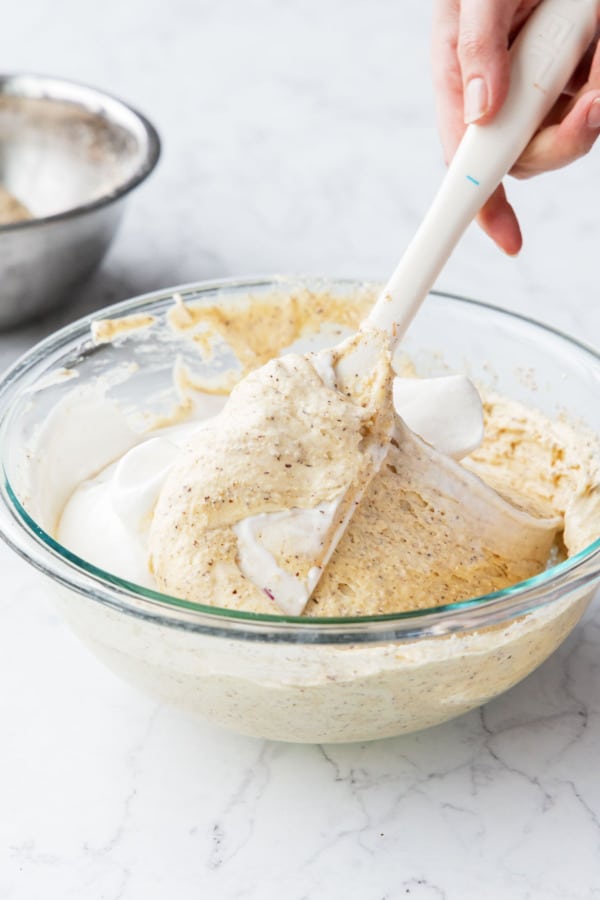 Gently folding in the rest of the egg whites into cake batter.