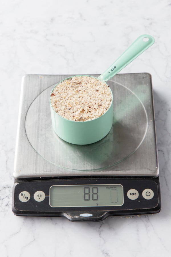 Half cup of hazelnut flour on a scale showing a weight of 88 grams.