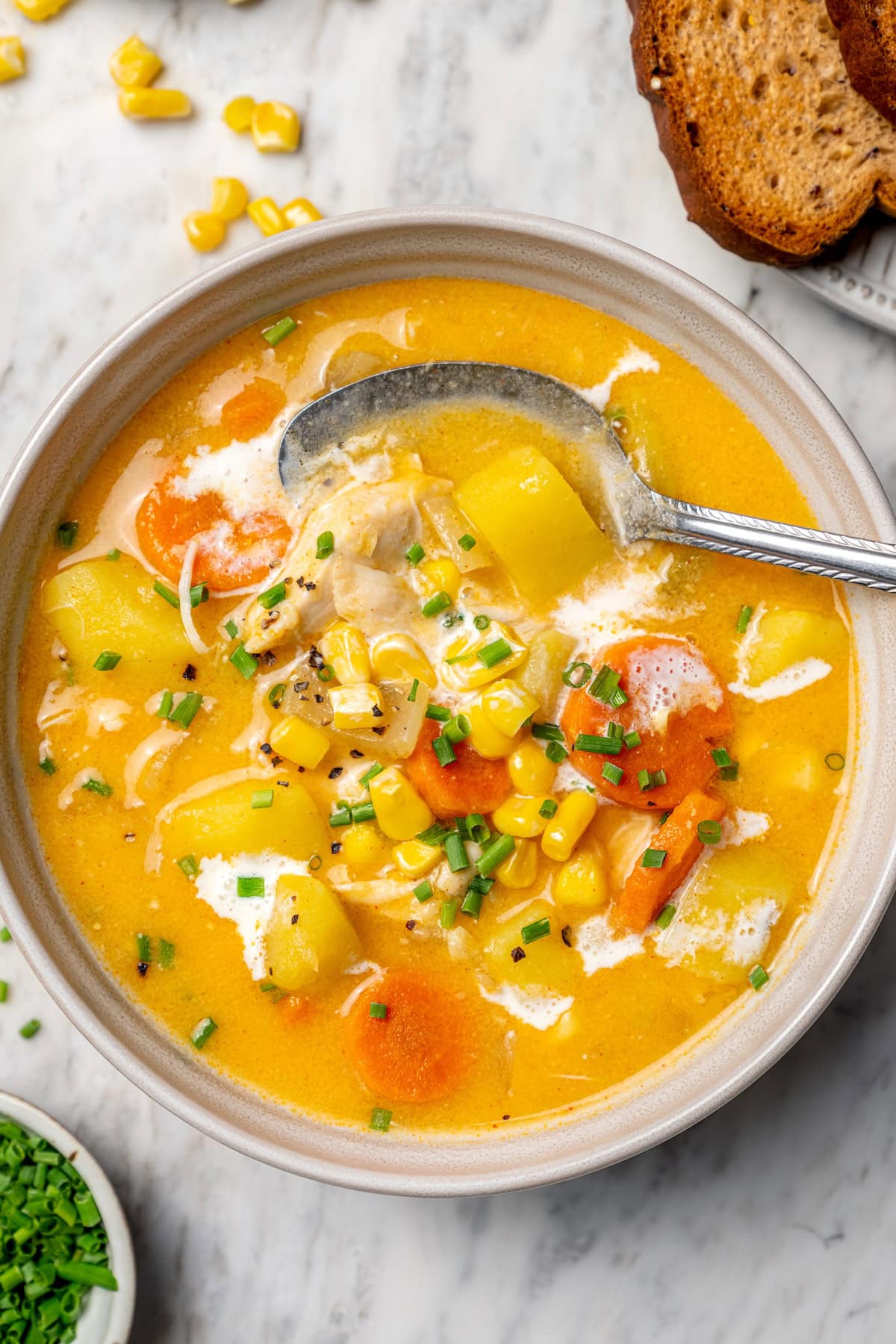 Chicken corn chowder in bowl with spoon.