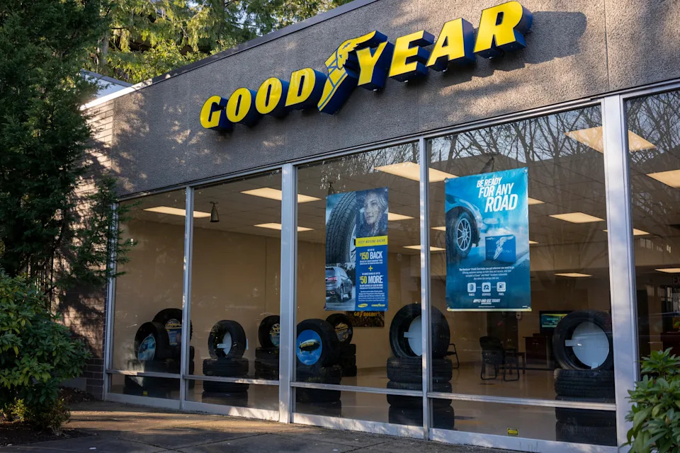 Goodyear tire shop exterior with display windows showing tires and promotional posters