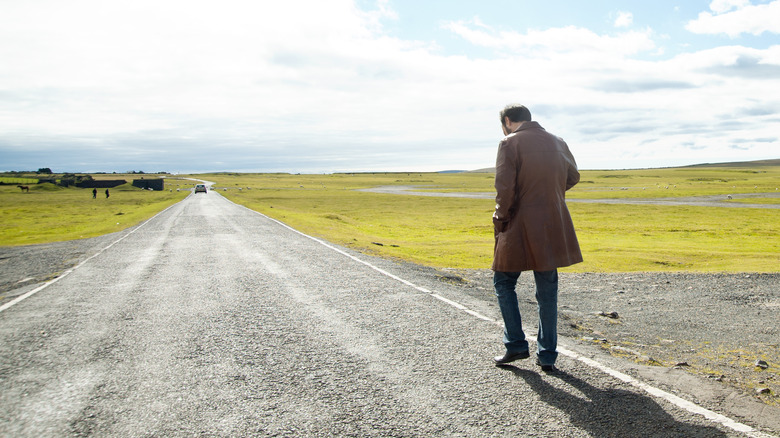 A man walking along an empty road