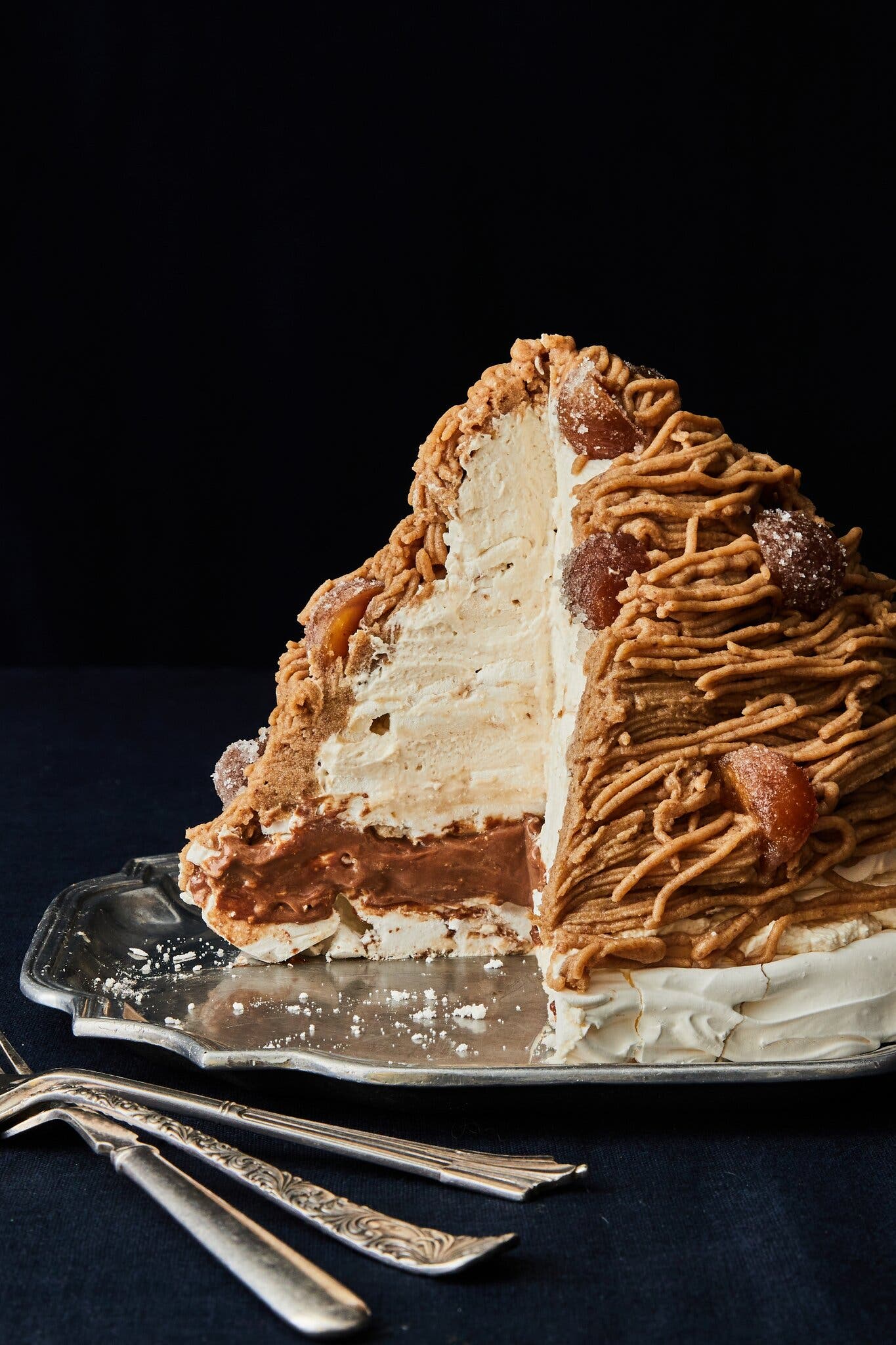 A side image of a giant Mont Blanc with a large slice taken out to expose a creamy interior.