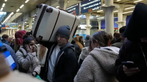 Reuters A passenger carries a suitcase